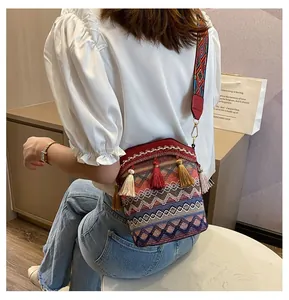 Dettaglio borsa a secchiello boho intrecciata con nappe colorate e tracolla etnica