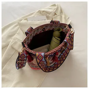 Detail of bohemian woven tote bag with colorful tassels showing spacious inner capacity