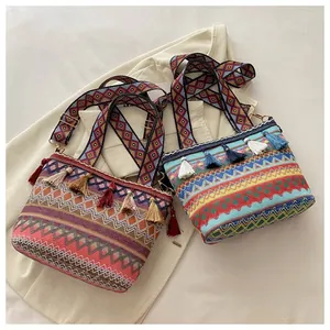 Detail of bohemian woven crossbody bags with colorful tassels and geometric straps