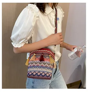 Dettaglio della borsa a secchiello boho con motivi geometrici colorati e lunghe nappe vivaci