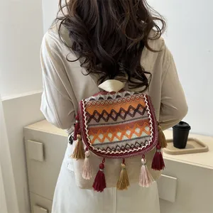 Detail der bunten ethnischen Stickerei und langen Quasten am Mini-Leinwandrucksack