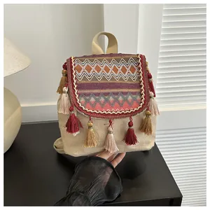 Nahaufnahme des Ethno-Rucksacks mit bunten Stickereien und dekorativen Quasten-Anhängern
