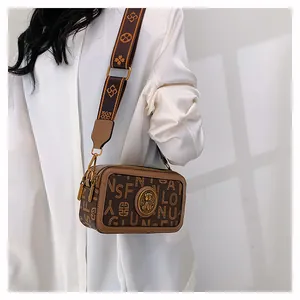 Dettaglio della borsa vintage marrone con stampa monogramma e tracolla larga