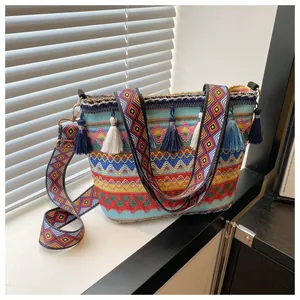 Close-up of bohemian woven bag featuring colorful wave patterns and fringe tassels