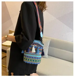 Dettaglio borsa a secchiello boho con motivi a onde colorate e nappe a triplo strato