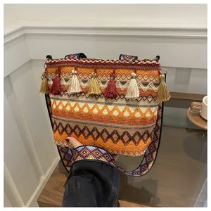 Detailed macro of Bohemian woven crossbody bag with colorful tassels and geometric patterns