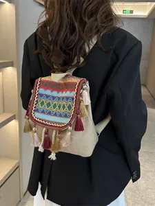 Ethno-Rucksack im Boho-Stil mit geometrischen Mustern und Quasten auf beigem Canvas