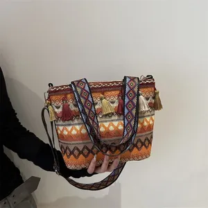 Bohemian woven crossbody bag with geometric patterns, ethnic tassels and dual straps