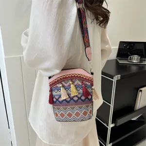 Dettaglio della borsa a secchiello etnica con trama colorata e nappine decorative