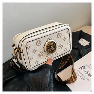 Dettaglio della borsa a tracolla con motivo monogramma e stemma in metallo dorato fine