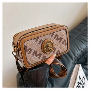 Dettaglio borsa a tracolla con emblema dell'orso dorato retrò e motivo jacquard
