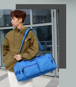 Sac de sport bleu imperméable avec maille latérale et bandoulière sur le mannequin