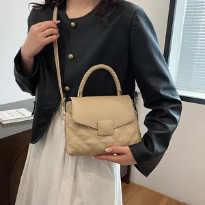 Beige quilted handbag with woven handle and cross-body strap shown on a model
