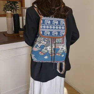 Rear view of ethnic backpack with blue elephant embroidery and brown leather trim detail