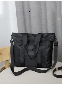 Détail du sac cabas noir minimaliste avec texture en nylon et bandoulière réglable