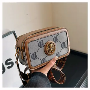 Dettaglio macro della borsa vintage con manico in pelle ed emblema di orso dorato