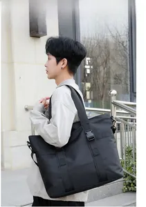 Détail du grand sac cabas noir avec éléments en cuir de vachette et sangle réglable à l'extérieur