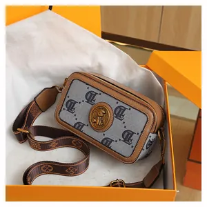 Dettaglio borsa fotografica retrò in tela grigia con logo e pelle marrone in scatola regalo