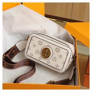 Dettaglio borsa fotografica beige con emblema di gatto e tracolla jacquard marrone