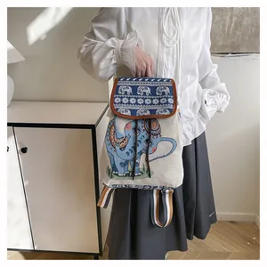Close-up of ethnic elephant embroidery and striped strap on the canvas backpack