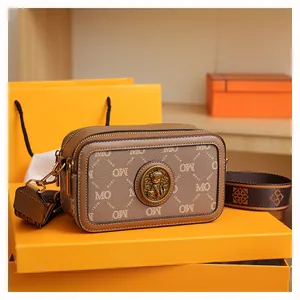 Dettagli della borsa fotografica marrone vintage con motivo floreale e fibbia in orso