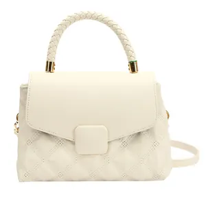 Beige quilted handbag with woven top handle and gold hardware for crossbody wear