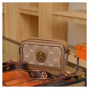 Dettaglio della borsa fotocamera a contrasto con stampa monogramma e tracolla jacquard