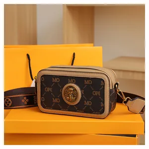 Dettaglio della borsa fotografica vintage con stampa monogramma e fibbia a rilievo dorata