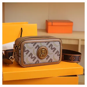 Dettaglio della borsa a tracolla jacquard con doppia cerniera ed emblema oro su scatola