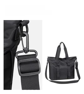 Détail de boucles en métal noir et bandoulière amovible sur un sac cabas en nylon