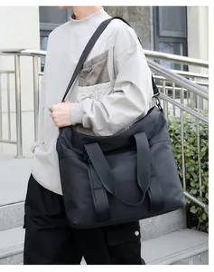 Détail du grand sac cabas noir avec poignées en sangle et bandoulière réglable pratique