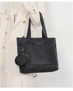Dettaglio della borsa tote in nylon nero con pochette rotonda e tasca frontale ampia