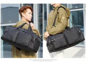 Détails d'un sac de voyage noir imperméable avec poches multiples et bandoulière