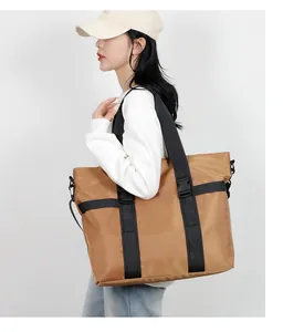 Vue latérale du grand sac cabas en nylon kaki avec sangles noires sur modèle