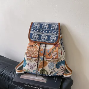 Detailed close-up of ethnic jacquard backpack featuring orange elephant embroidery and straps