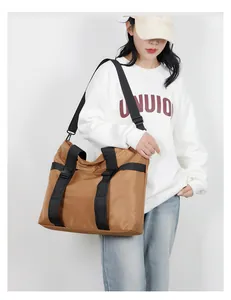 Détail du grand sac cabas jaune terreux montrant les sangles en nylon et la boucle