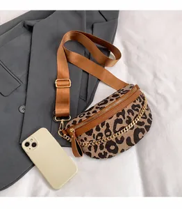 Detail of leopard print chest bag featuring gold chain decor and brown fabric strap