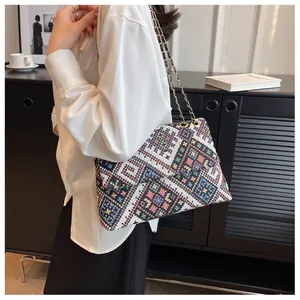 Detailed view of bohemian knit shoulder bag with colorful geometric patterns and chain strap