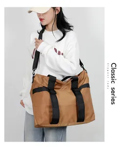Sac fourre-tout en nylon marron avec sangles noires porté par un mannequin en ville