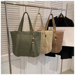 Three colors of handmade woven straw tote bags with decorative wooden bead tassels