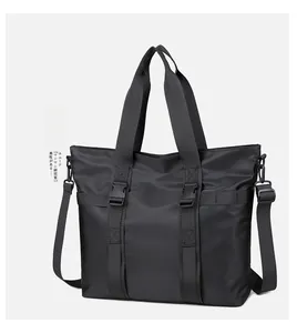 Détail du sac cabas noir avec sangles à boucle et bandoulière amovible réglable