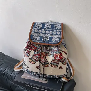 Detail of embroidered elephant backpack with drawstring closure and blue striped straps