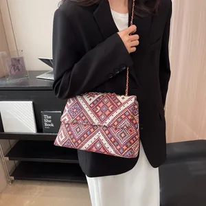 Ethnic knit crossbody bag with geometric patterns and leather chain strap on model