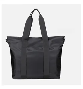 Détail d'un grand sac cabas noir en nylon avec poignées renforcées et anneau en D latéral