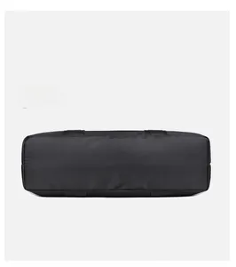 Vue détaillée du dessous du grand sac fourre-tout noir en nylon avec poignées