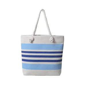 Dettaglio della borsa tote in tela a righe blu nautico con manici in corda di cotone bianco