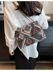 Bohemian large chain shoulder bag with colorful geometric woven pattern worn by a model