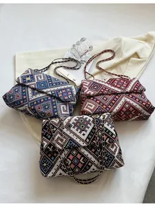 Three large woven chain shoulder bags with geometric patterns in blue, red, and black