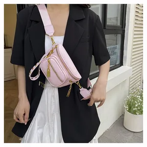 Borsa a tracolla rosa texture litchi con cerniere multiple indossata da una modella