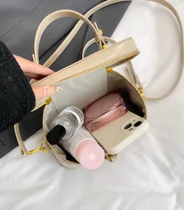 Detailansicht des geräumigen Innenfachs der beigen Kunstleder-Handtasche mit Reißverschluss